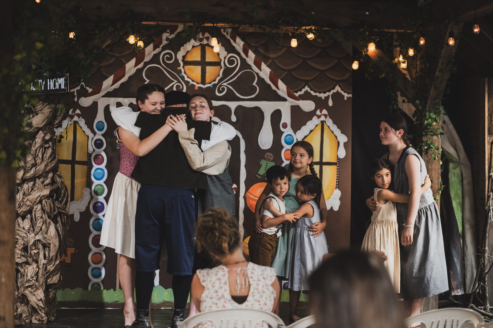 The cast embraces at the curtain call